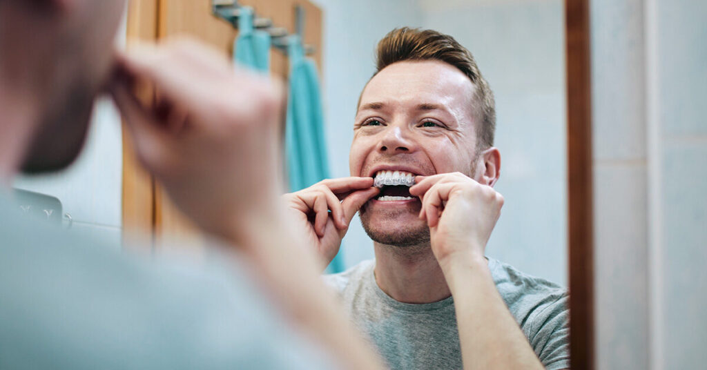 person using over-the-counter teeth whitening products