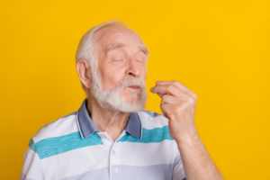 Older man making “chef’s kiss” gesture on a bright yellow background